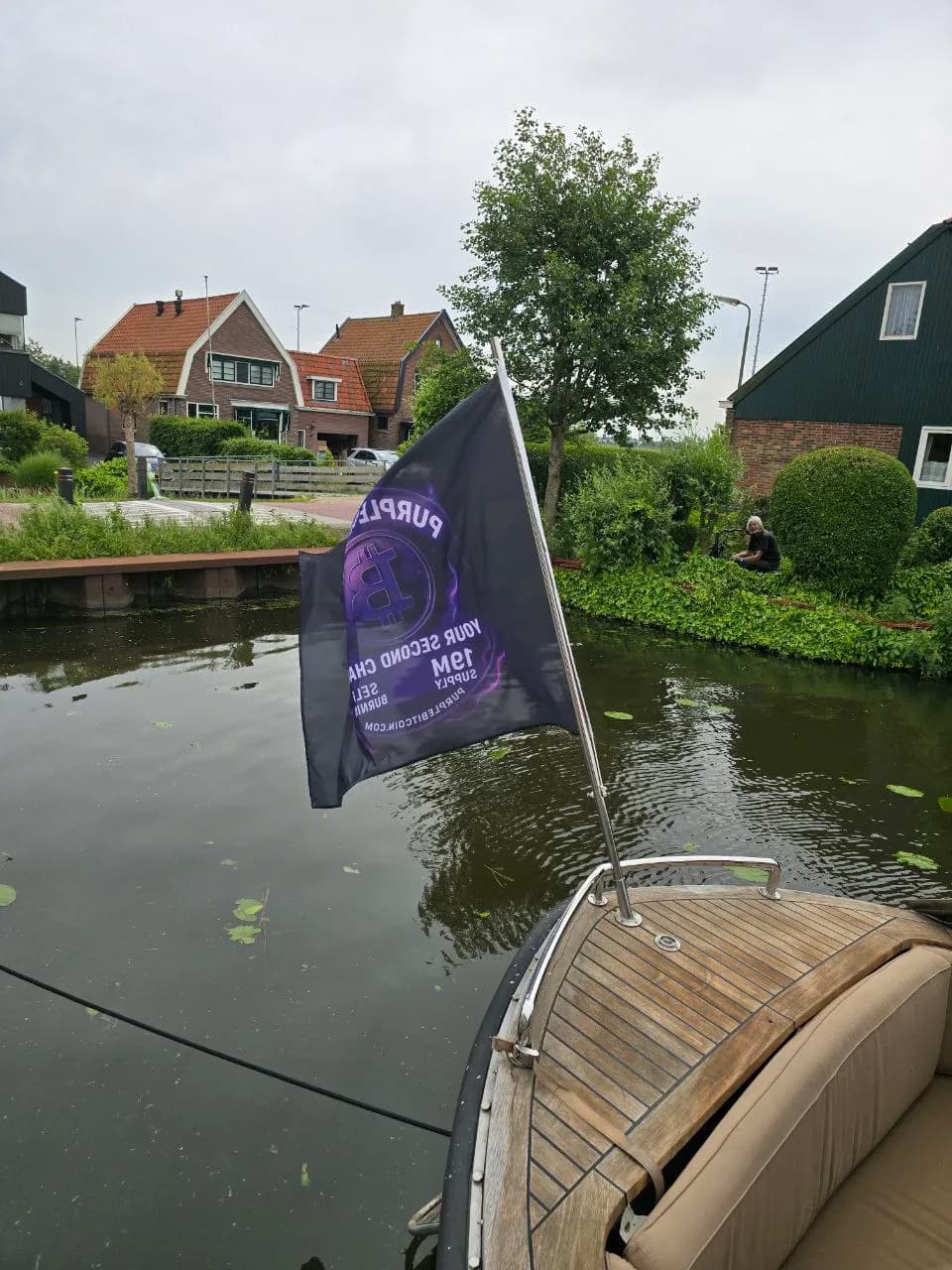 Purple Bitcoin flag displayed at a waterside community event