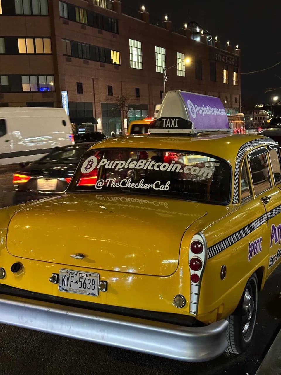 Purple Bitcoin Checker Cab wrap on a New York taxi at night